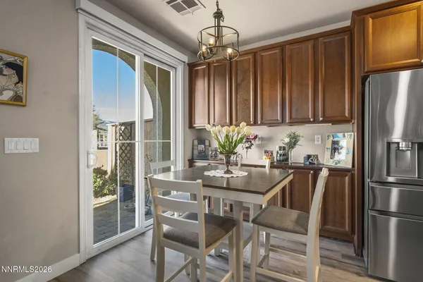 a dining room with furniture a chandelier and wooden floor