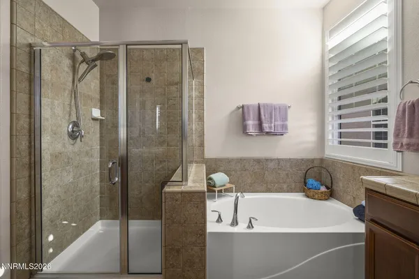 a bathroom with a tub a window and a shower
