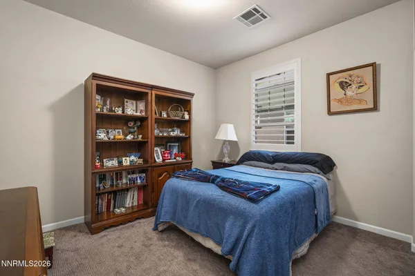 a bedroom with bed and a bookshelf