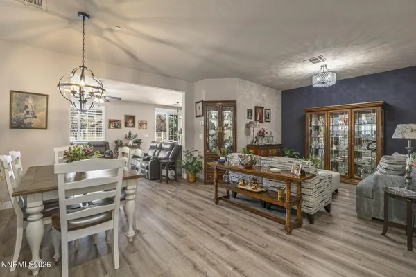 a living room with furniture a chandelier and a dining table