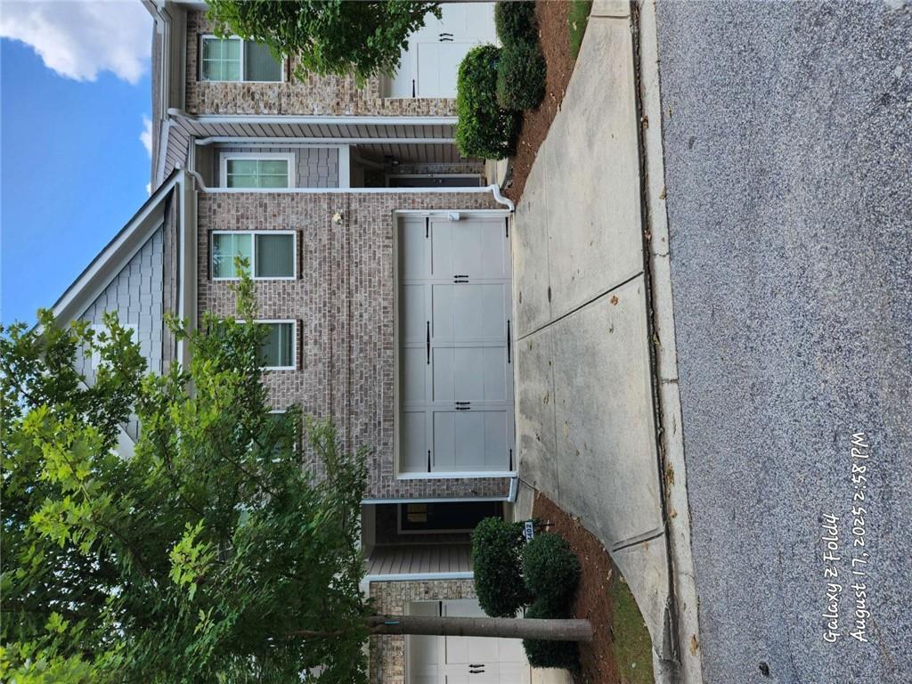 a view of a house with a yard and large tree