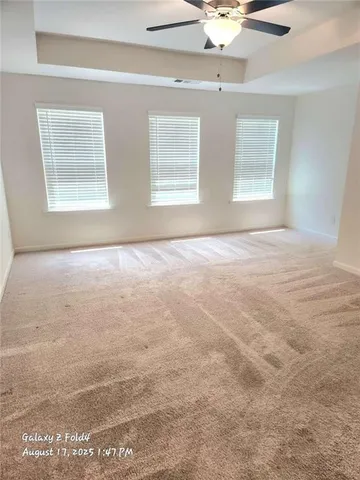 an empty room with a ceiling fan and window