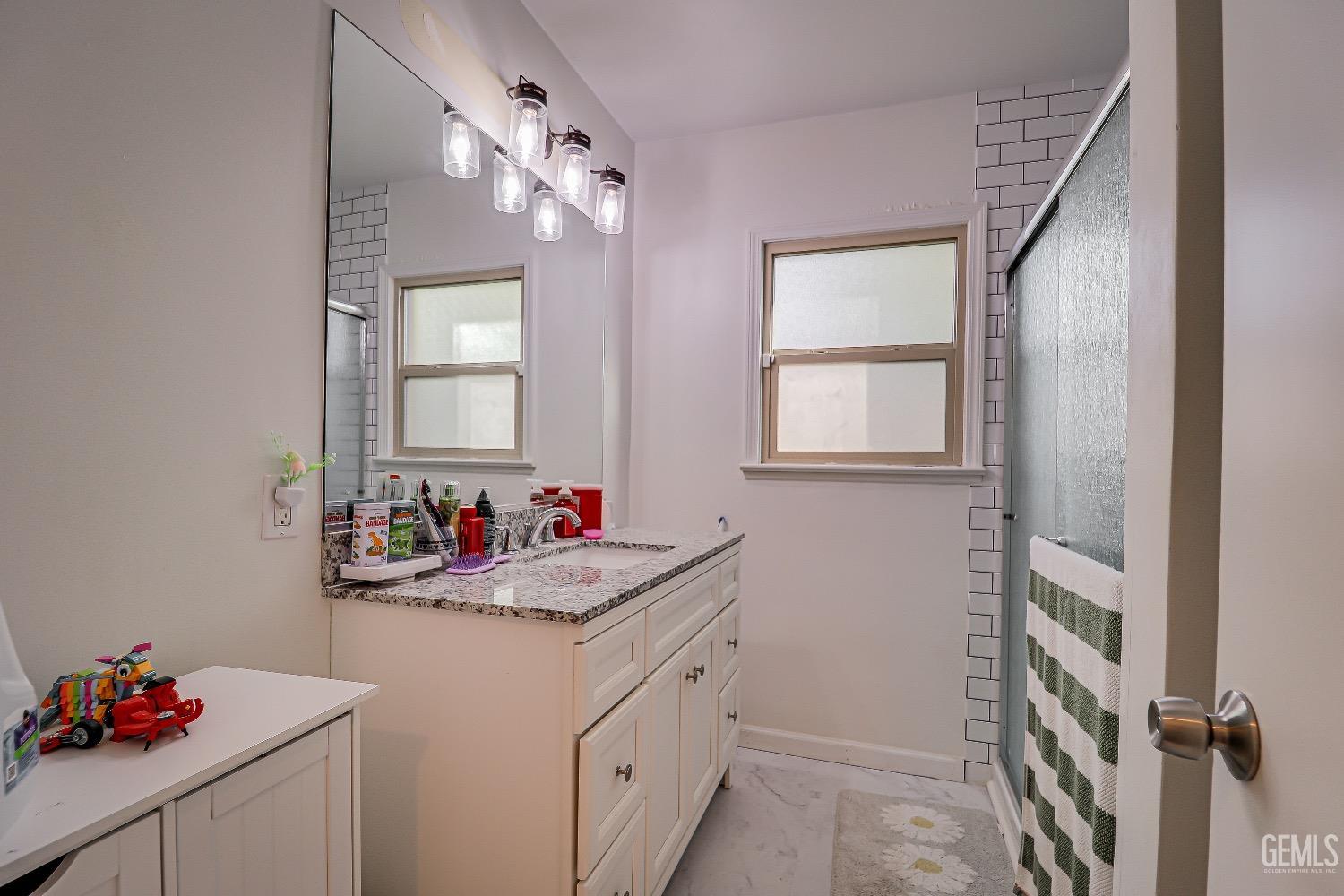 Undisclosed Address Bakersfield, CA 93304 - Photo 13 of 26 a bathroom with a sink vanity and a mirror