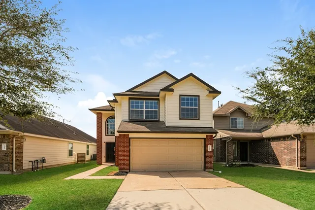 a front view of a house with a yard and garage