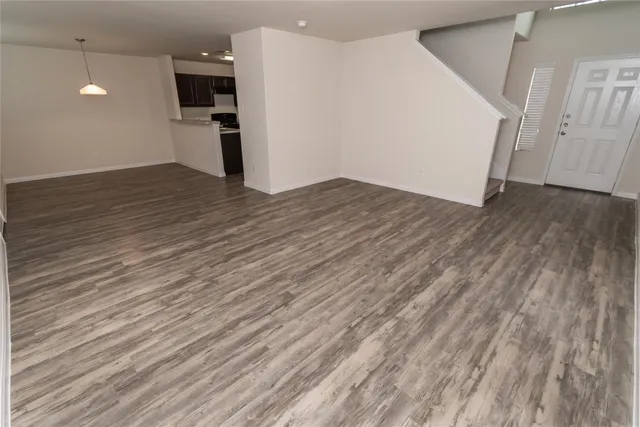 a view of a kitchen with wooden floor and a refrigerator
