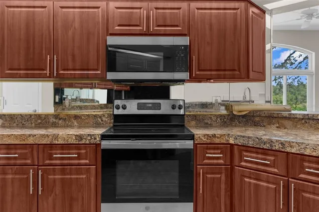 a bedroom with a large bed couch and two windows