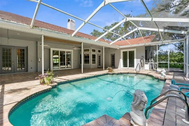 a view of a swimming pool with a patio and backyard