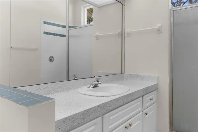 an empty room with a chandelier fan and windows