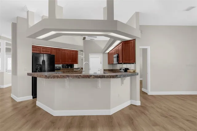 a kitchen with granite countertop a stove top oven microwave and cabinets