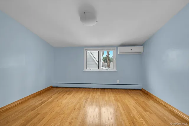 an empty room with a window and wooden floor