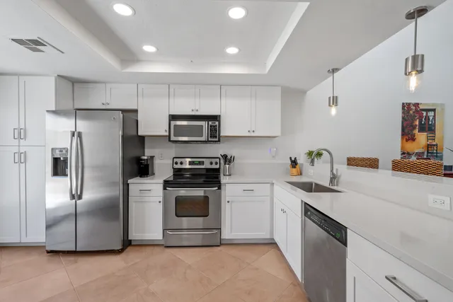 a kitchen with stainless steel appliances granite countertop a refrigerator sink and stove