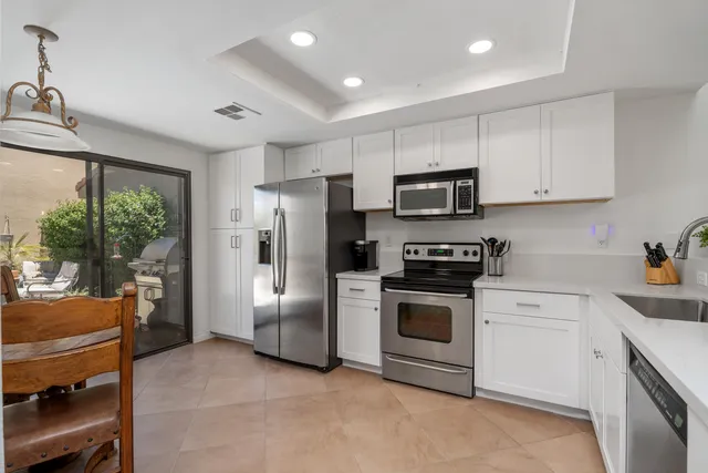 a kitchen with stainless steel appliances granite countertop a stove a refrigerator and a stove top oven