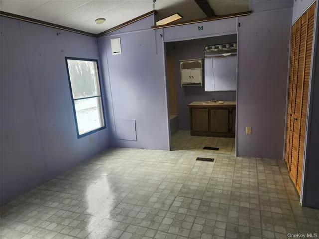 a view of an empty room with windows and closet