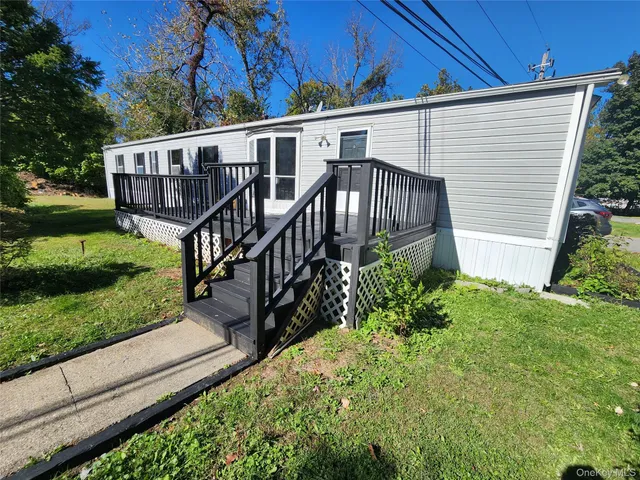 a view of a house with wooden stairs and a small yard