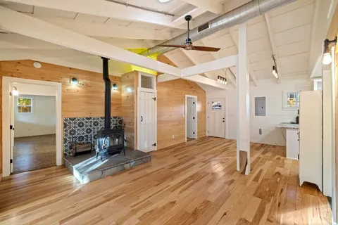 a view of a livingroom with a furniture a ceiling fan and wooden floor