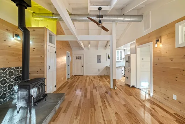 a open kitchen with stainless steel appliances granite countertop a refrigerator a sink dishwasher and a stove with wooden floor