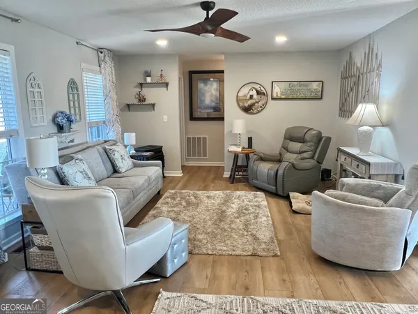 a living room with furniture and a wooden floor