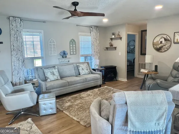 a living room with furniture a clock on wall and a window