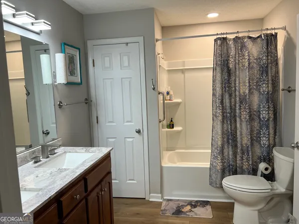 a bathroom with a granite countertop sink toilet and shower
