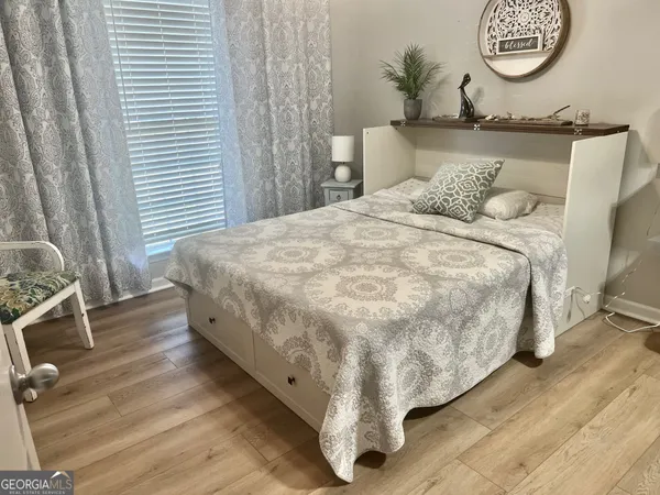 a large bed sitting in a bedroom next to a window