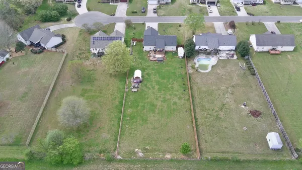 an aerial view of a house with swimming pool and a yard