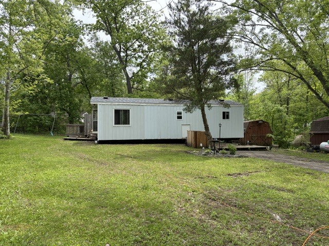 a view of a house with backyard and a tree