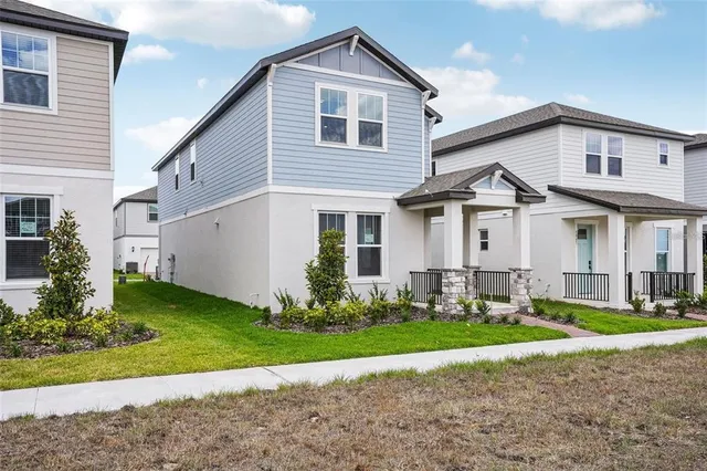a front view of a house with a yard and trees
