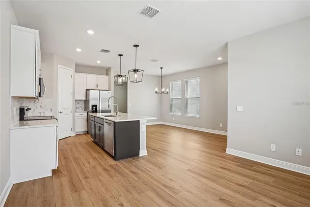 a kitchen with a refrigerator and a stove top oven