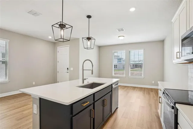a kitchen with a sink a counter space and wooden floor