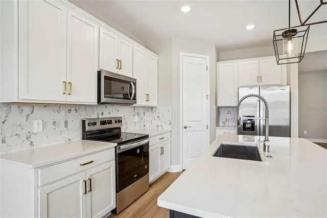 a kitchen with a sink a stove and cabinets