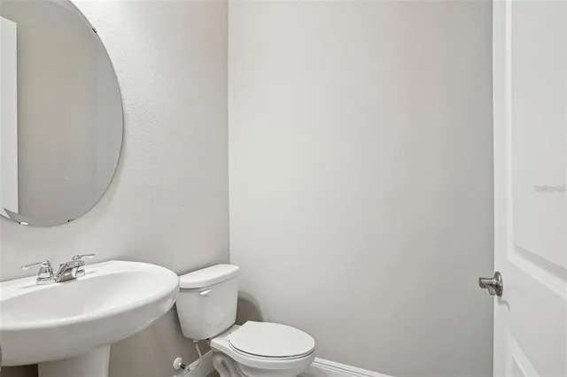 a white toilet sitting next to a bathroom sink