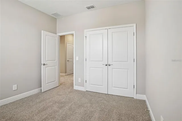 an empty room with windows and closet