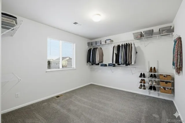 a view of walk in closet with clothes and shoes