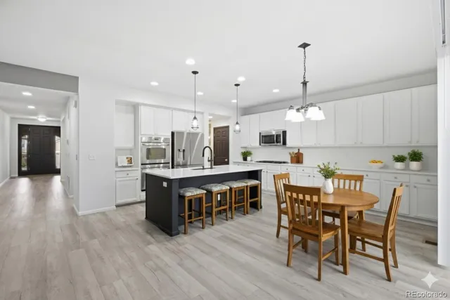 a view of kitchen with cabinets stainless steel appliances dining table and chairs