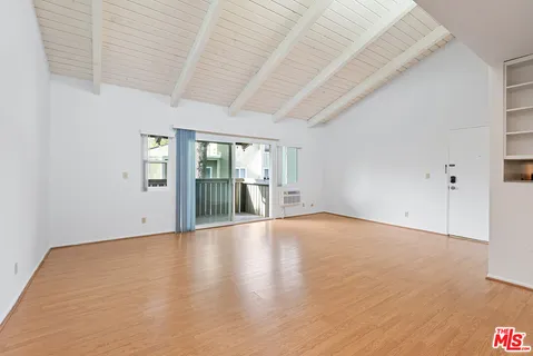a view of an empty room with glass door and entryway