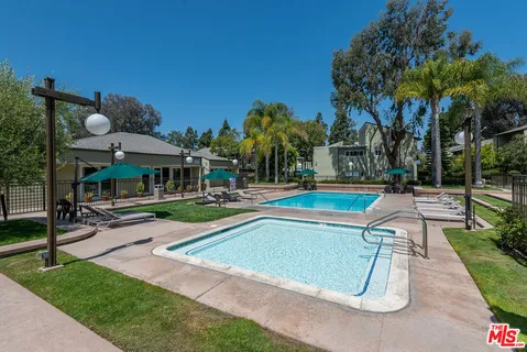 a view of backyard with swimming pool and seating space