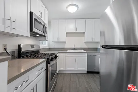 a kitchen with stainless steel appliances granite countertop a stove a sink and a refrigerator