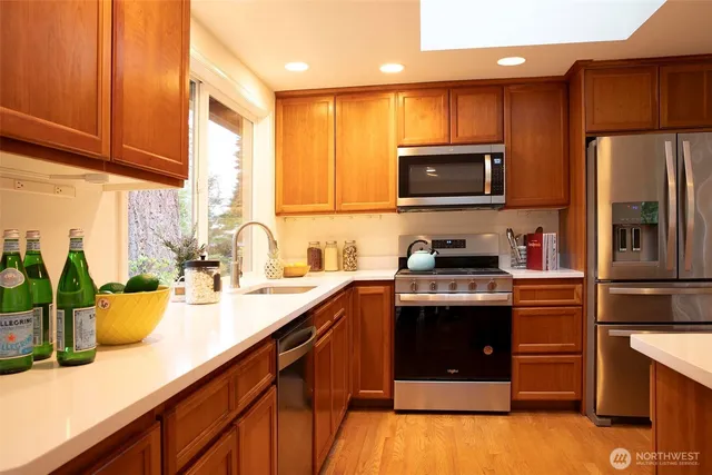 a kitchen with kitchen island a sink appliances and cabinets
