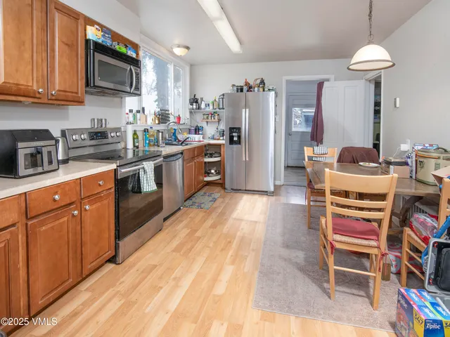 a kitchen with stainless steel appliances kitchen island granite countertop a refrigerator a stove top oven a sink and dishwasher