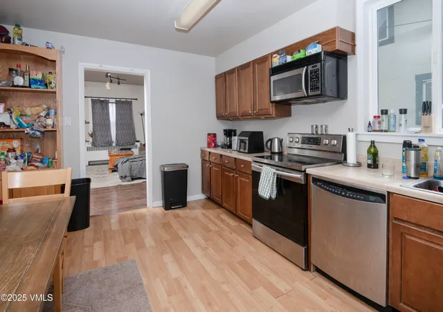 a kitchen with stainless steel appliances granite countertop a stove a sink dishwasher and a microwave oven with cabinets