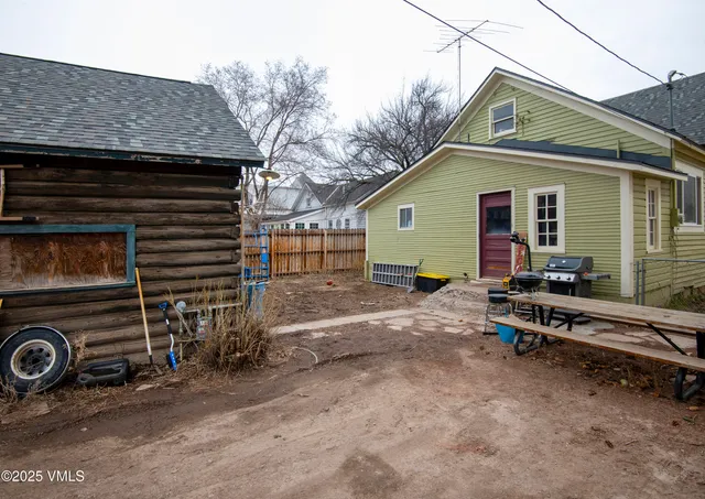 a view of a house with a backyard and wooden fence