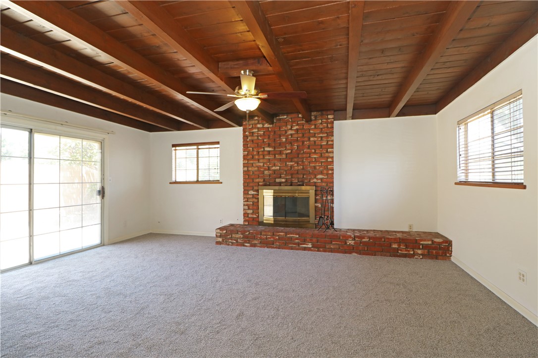 721 North Milford Road Orange, CA 92867 - Photo 10 of 38 Spacious living room with exposed wood beams, brick fireplace and new carpet.