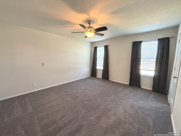 an empty room with closet and a ceiling fan