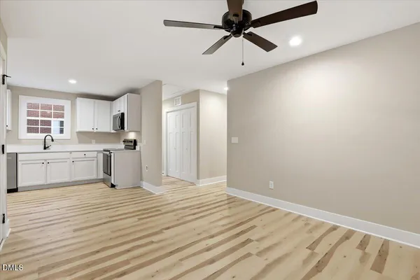 a view of a kitchen with wooden floor and a ceiling fan