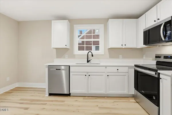 a kitchen with a sink cabinets and window
