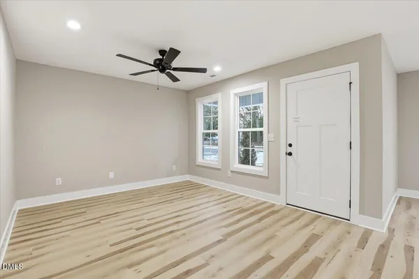 a view of a big room with wooden floor and windows in a room