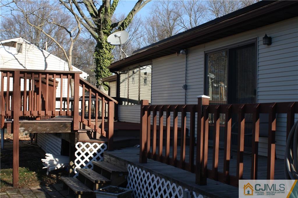 179 Princeton Road Old Bridge, NJ 08859 - Photo 22 of 24 a view of a house with wooden deck stairs and a potted plant
