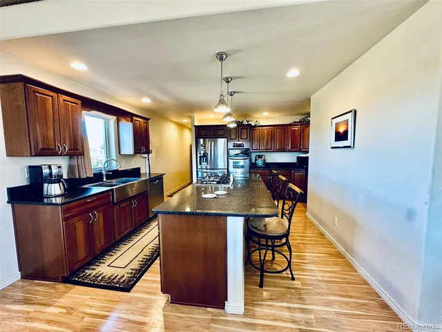 a kitchen with stainless steel appliances granite countertop a stove and a wooden cabinets