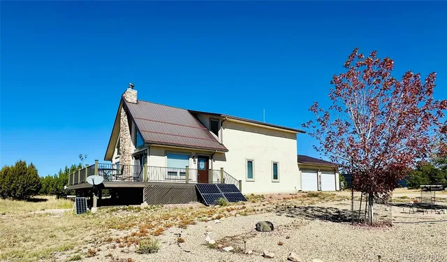 a view of a house with a wooden deck and a mountain