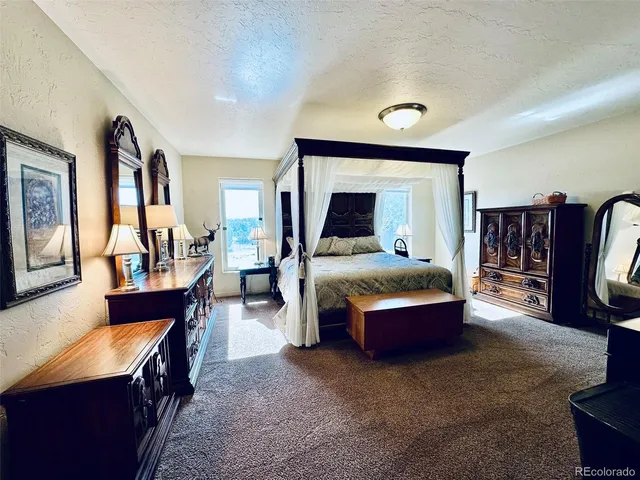 a bedroom with a bed and a large mirror on the dresser